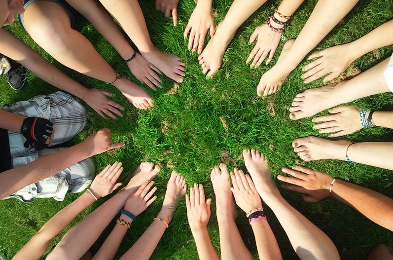 grupo de adolescentes saludables, unidos por sus manos y pies